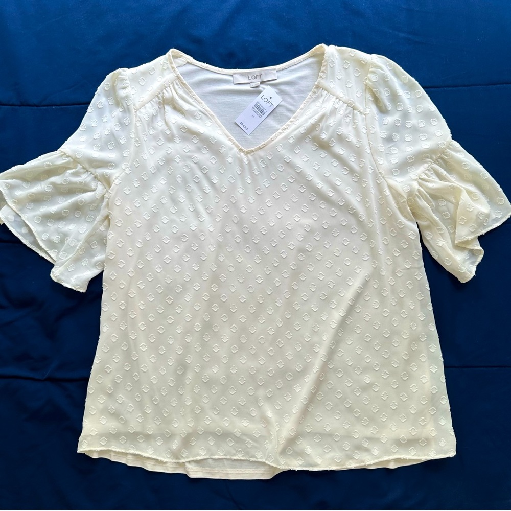 Cream blouse with raised circle design.